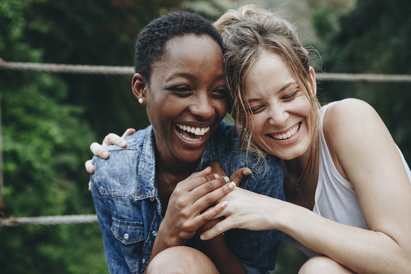 two women laughing and smiling together - try betterhelp online therapy today
