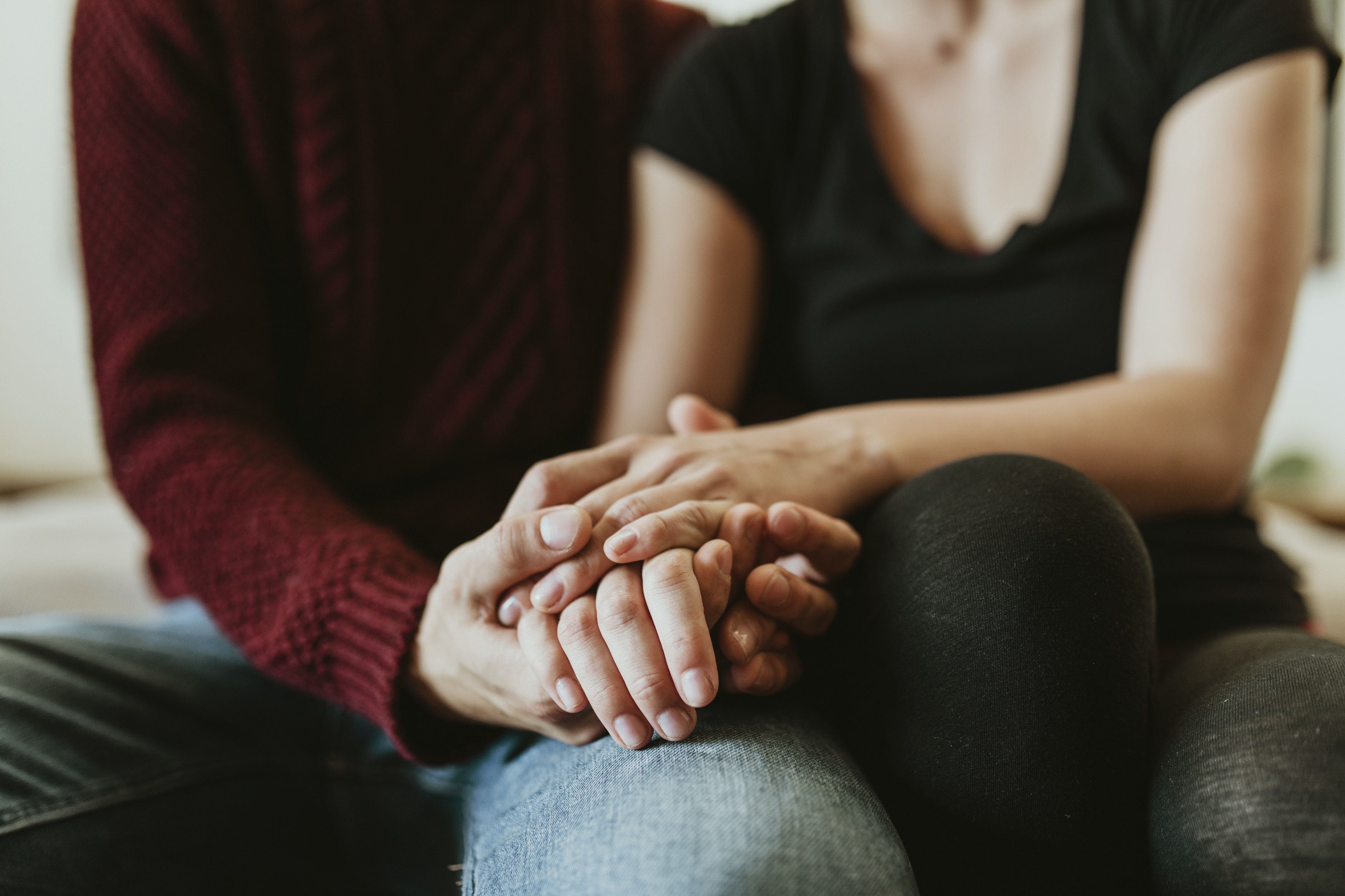 A close-up of a married couple holding hands, after attending a counseling session that helped them be vulnerable with each other.
