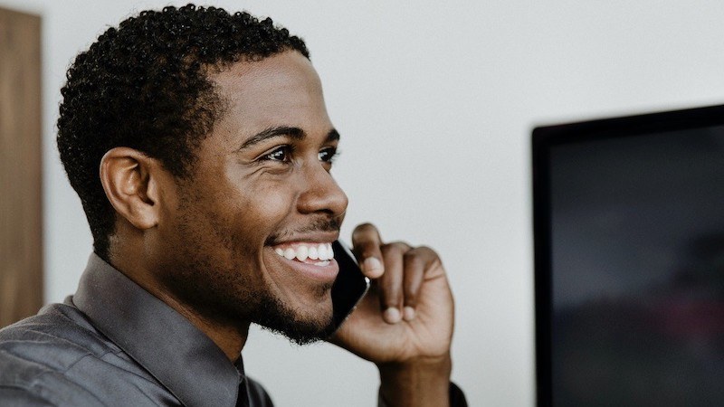 phone online therapy session - man smiling while talking on phone