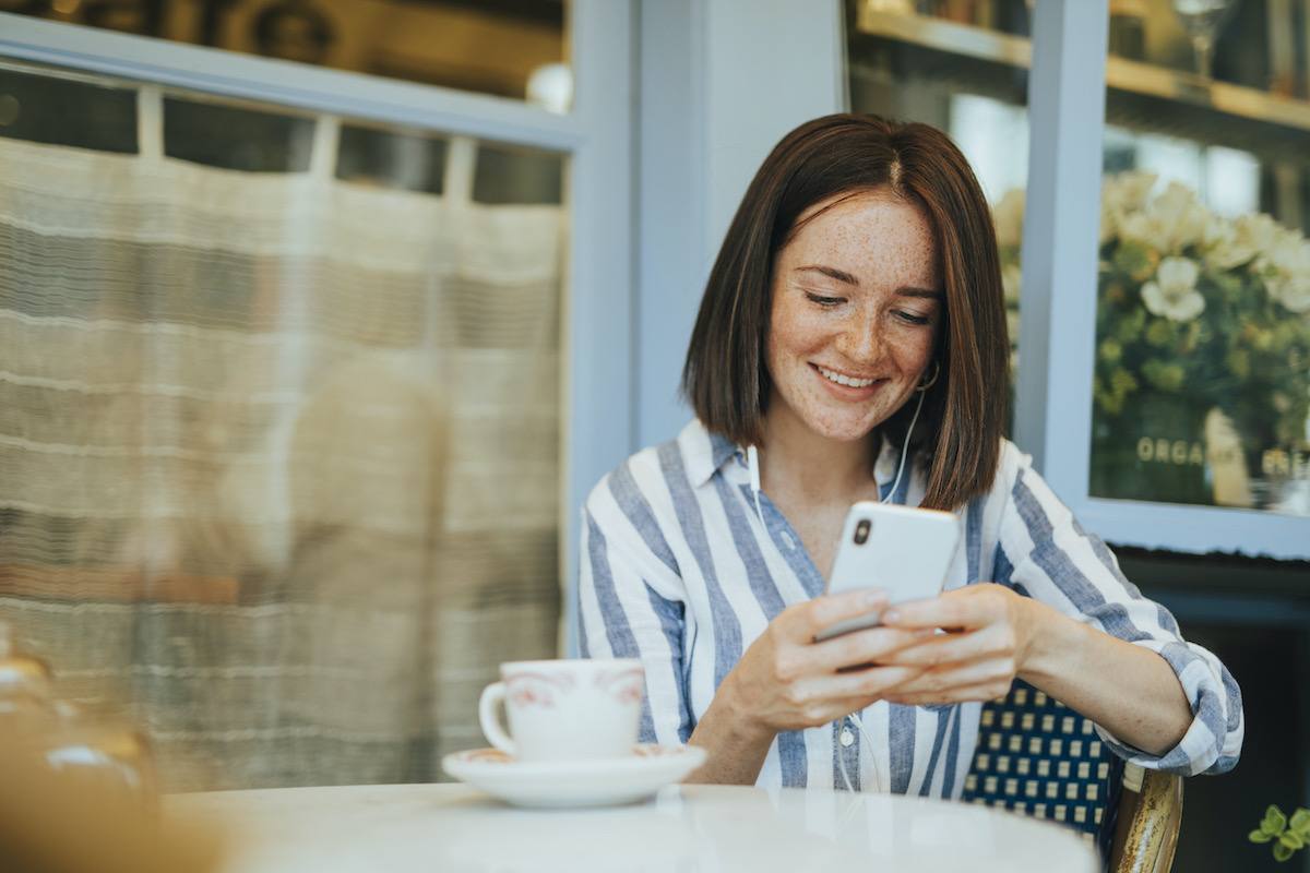 在最好的在线治疗平台上，女人微笑着看着她的手机